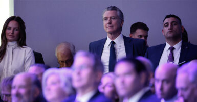 DAVOS, SWITZERLAND - JANUARY 21: California Governor Gavin Newsom (C) listens to U.S. President Donald Trump address the World Economic Forum (WEF) in the Davos Congress Center on January 21, 2026 in Davos, Switzerland. The annual meeting of political and business leaders comes amid rising tensions between the United States and Europe over a range of issues, including Trump's vow to acquire Greenland, a semi-autonomous Danish territory. (Photo by Chip Somodevilla/Getty Images)