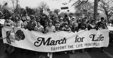Black-and-white photo of a group of marchers behind sign reading "March for Life: Support the life principles."
