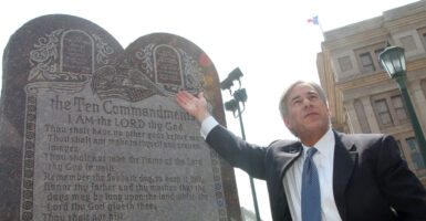 Greg Abbott gestures toward a Ten Commandments monument outside Texas State Capitol building in 2005.