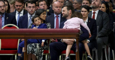 JD and Usha Vance look at each other lovingly while seated, each with a child in their lap.
