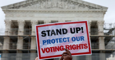 Demonstrator with voting rights sign at Supreme Court of the United States on March 24, 2025.
