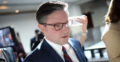 Speaker of the House Mike Johnson speaks to reporters in a capitol hallway.