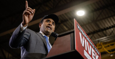 Vivek Ramaswamy stands at a podium and gestures.