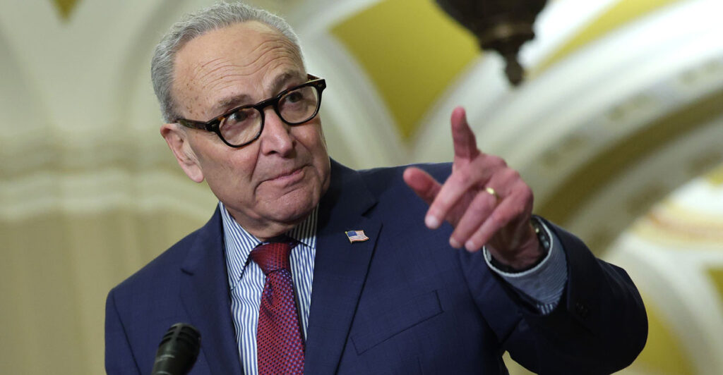 Sen. Chuck Schumer points as he speaks to reporters at a Capitol press conference.