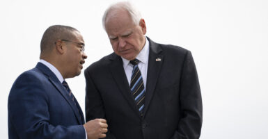 (L-R) Minnesota Attorney General Keith Ellison and Minnesota Governor Tim Walz await the arrival of US Vice President Kamala Harris at the Minneapolis-St. Paul International Airport in Saint Paul, Minnesota, on March 14, 2024. Harris toured an abortion clinic, highlighting a key election issue in what US media reported was the first such visit by a president or vice president. (Photo by STEPHEN MATUREN / AFP) (Photo by STEPHEN MATUREN/AFP via Getty Images)