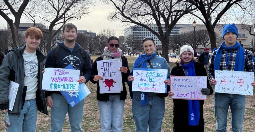 A group of young people holding up signs at the March for Life 2026