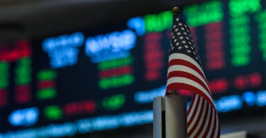 An American flag is displayed on a desk on the floor of the New York Stock Exchange (NYSE) at the opening bell on July 15, 2025, in New York City. Global stock markets went in different directions on Tuesday, as an uptick in US inflation suggested President Donald Trump's tariffs could be beginning to feed into the American economy. New York was generally trading higher on the back of healthy results from major US banks and buoyant news in the tech sector. The S&P 500 and Nasdaq were up, though the Dow Jones was struggling. Most Asian indices rose but Europe's stock markets slipped into the red late in the day. (Photo by ANGELA WEISS / AFP) (Photo by ANGELA WEISS/AFP via Getty Images)
