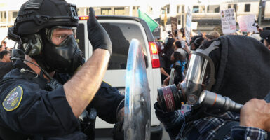 A US Department of Homeland Security (DHS) Federal Protective Service (FPS) officer wears a gas mask while blocking a flashlight as protestors clash with Federal agents and police outside the Edward R. Roybal Federal Building and Metropolitan Detention Center during a "National Shutdown" protest against US Immigration and Customs Enforcement in Los Angeles, California on January 30, 2026. Donald Trump's border chief said January 29, 2026 that some federal agents could be withdrawn from Minneapolis, the northern US city that has become the flashpoint for the president's immigration crackdown. The Trump administration, facing a public backlash over the shooting deaths of two Americans by federal agents in Minneapolis, also eased immigration operations in the northeastern state of Maine. (Photo by Patrick T. Fallon / AFP via Getty Images)