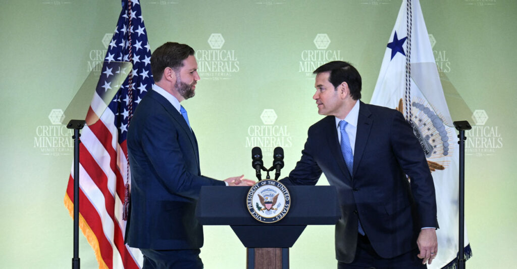 JD Vance and Marco Rubio shake hands behind a podium