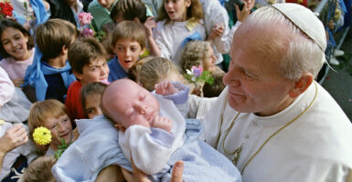 Pope John Paul II blesses 06 October 1986 in Ars a baby during the third day of his visit to Lyon's area. The pontiff was visiting from 04 to 07 October East and Central regions of France (it was his 31th International Pastoral visit). AFP PHOTO DANIEL JANIN (Photo credit should read DANIEL JANIN/AFP via Getty Images)