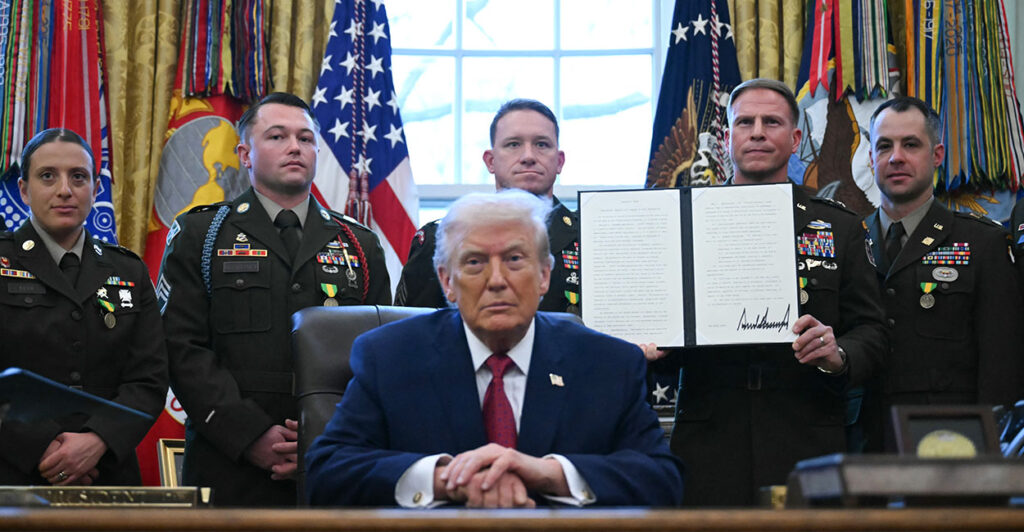 A service member holds an executive order by President Donald Trump signed during a Mexican Border Defense Medal presentation in the Oval Office on Dec. 15. (Photo by ANDREW CABALLERO-REYNOLDS / AFP via Getty Images)