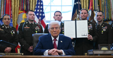 A service member holds an executive order by President Donald Trump signed during a Mexican Border Defense Medal presentation in the Oval Office on Dec. 15. (Photo by ANDREW CABALLERO-REYNOLDS / AFP via Getty Images)