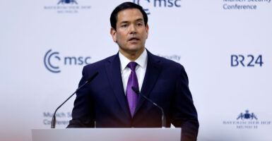Marco Rubio in a purple tie speaks at a podium in front of white background with Munich Security Conference MSC logo.