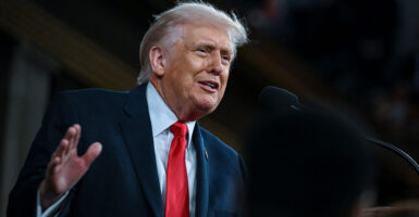 Low angle shot of President Trump, his right hand raised delivering the State of the Union.