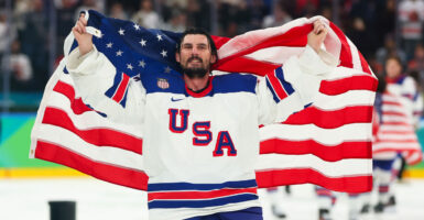 MILAN, ITALY - FEBRUARY 22: Connor Hellebuyck #37 of Team United States celebrate a 2-1 victory against Canada in overtime for the gold medal during the Men's Gold Medal match between Canada and the United States on day 16 of the Milano Cortina 2026 Winter Olympic games at Milano Santagiulia Ice Hockey Arena on February 22, 2026 in Milan, Italy. (Photo by Gregory Shamus/Getty Images)