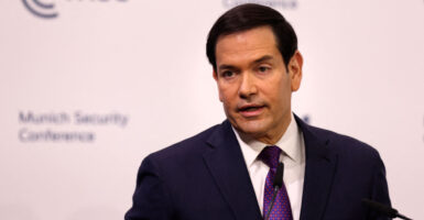 Marco Rubio delivers a speech against a white background.