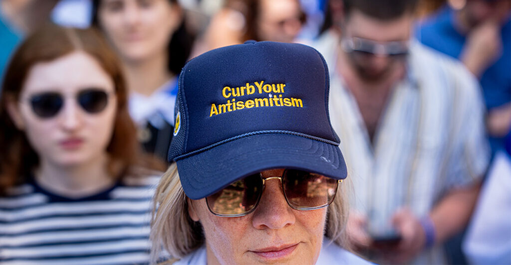 WASHINGTON, DC - MAY 2: A woman wears a hat that reads "Curb Your Antisemitism" during a rally against campus antisemitism at George Washington University on May 2, 2024 in Washington, DC. A pro-Palestinian rally was also held at the school today, as protestors at college campuses around the country call for schools to divest from Israeli interests amid the ongoing war in Gaza. (Photo by Andrew Harnik/Getty Images)