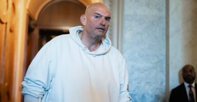 John Fetterman walks by the Senate chamber