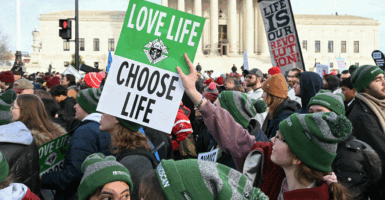 People hold "Love Life - Choose Life" signs in front of the US Supreme Court as they march in the 53rd annual March for Life rally in Washington, DC, on January 23, 2026. The annual pro-life demonstration, themed "Life is a Gift," marks the anniversary of the Roe v. Wade decision and includes a march toward Capitol Hill. (Photo by SAUL LOEB / AFP via Getty Images)