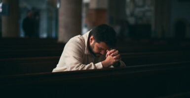 Young Man praying in Church.