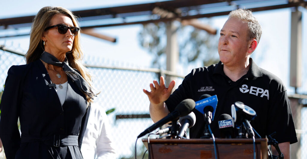 EPA Administrator Lee Zeldin speaks as SBA Administrator Kelly Loeffler looks on at a press conference in front of a destroyed school.