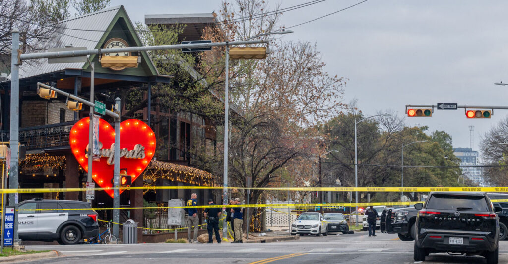 A view across the street toward Buford's bar in Austin, with police tape running across the street and police outside.