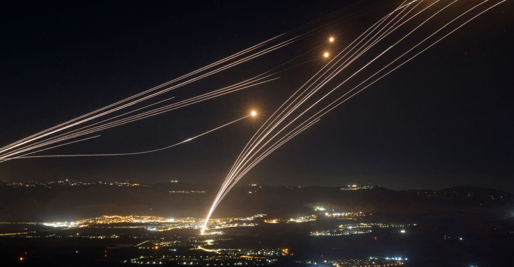Streaks of light from missile interceptors race into the night sky.