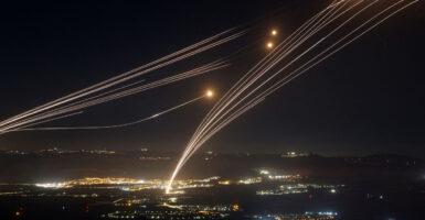 Streaks of light from missile interceptors race into the night sky.