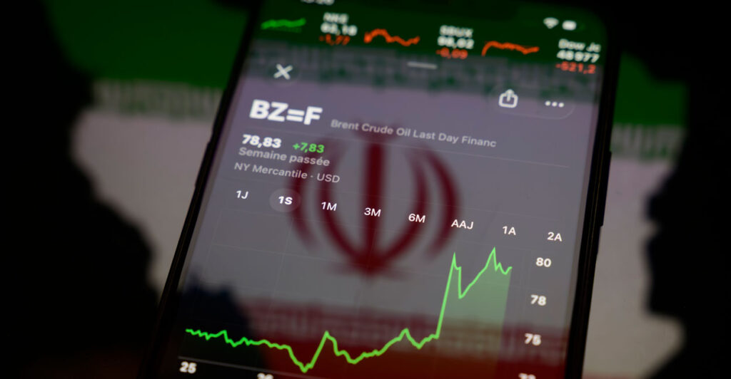 A smartphone showing graph indicating rise in crude oil prices against the background of an Iranian flag.