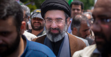 Mojtaba Khamenei, son of the late Iranian Supreme Leader Ali Khamenei walks amid a crowd of people.