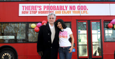 Professor Richard Dawkins (right) with Guardian journalist Ariane Sherine beside a bus displaying an atheist message in Kensington Gardens, London. (Photo by Anthony Devlin - PA Images/PA Images via Getty Images)