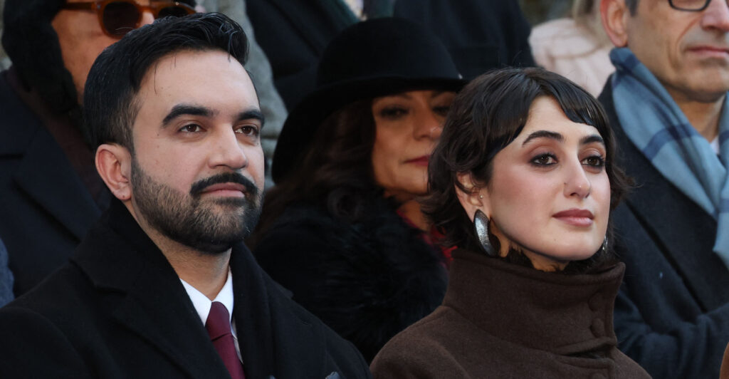 New York mayor Zohran Mamdani and his wife Rama Duwaji listen to the national anthem during his public inauguration ceremony followed by a block party at City Hall in New York on January 1, 2026. Mamdani, the young upstart of the US left, was sworn in Thursday to take over as New York mayor for a term sure to see him cross swords with President Donald Trump. After the clocks struck midnight, bringing in 2026, Mamdani took his oath of office at an abandoned subway stop to begin managing the United States' largest city. He is New York's first Muslim mayor. (Photo by TIMOTHY A.CLARY / AFP via Getty Images)