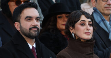 New York mayor Zohran Mamdani and his wife Rama Duwaji listen to the national anthem during his public inauguration ceremony followed by a block party at City Hall in New York on January 1, 2026. Mamdani, the young upstart of the US left, was sworn in Thursday to take over as New York mayor for a term sure to see him cross swords with President Donald Trump. After the clocks struck midnight, bringing in 2026, Mamdani took his oath of office at an abandoned subway stop to begin managing the United States' largest city. He is New York's first Muslim mayor. (Photo by TIMOTHY A.CLARY / AFP via Getty Images)
