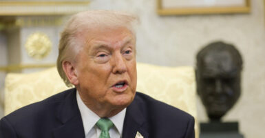 Close up of Donald Trump in Oval Office wearing a green tie.