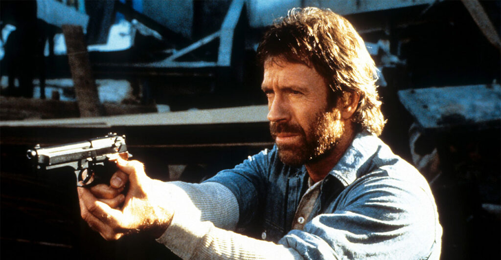 Chuck Norris points a gun in a scene from the film 'Hero And The Terror', 1988. (Cannon/Getty Images)