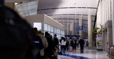 Long line stretching in airport terminal to pass through security.