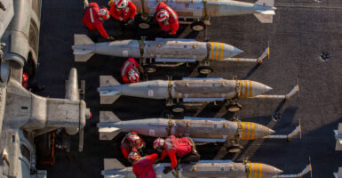 Overhead shot of U.S. Navy crew members inspecting a row of ordinance.
