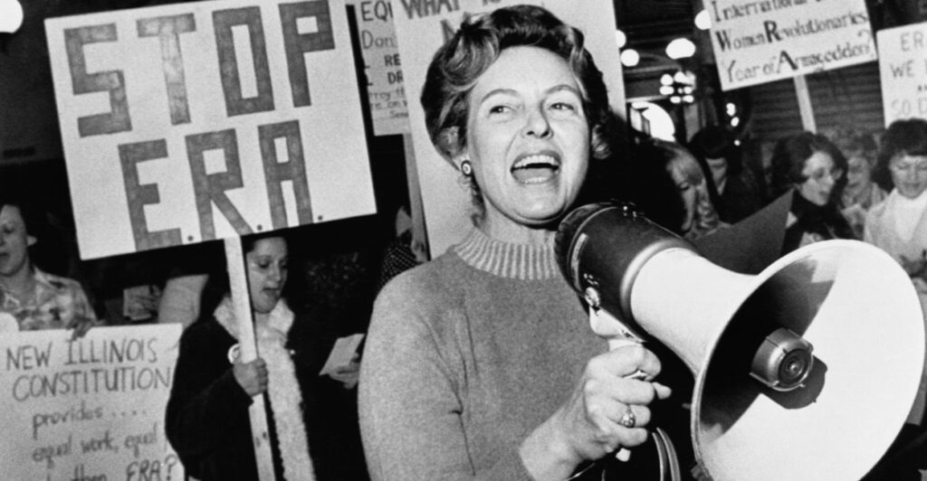 Black-and-white photo of Phyllis Schlafly, megaphone in hand, leading a rally against the Equal Rights Amendment.