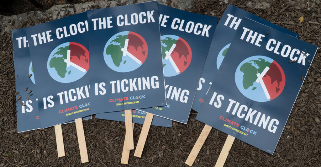 Several signs that read "The Clock is Ticking" lie in pile on the ground before Climate Emergency Day at Union Square, New York City, July 22, 2024. The text is a reminder that many believe humanity has only a few more years to make drastic changes to prevent average global temperatures from rising an additional 1.5 degrees Celsius.. (Photo by: John Senter/UCG/Universal Images Group via Getty Images)
