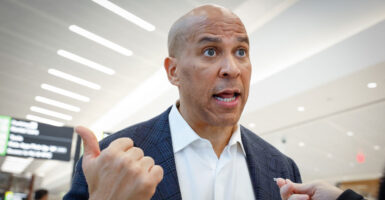 Senator Cory Booker speaks to a reporter at an ariport.
