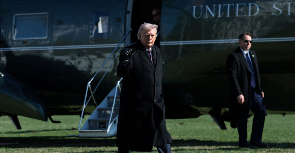 President Donald Trump gestures with his fist as he heads towards Marine One.