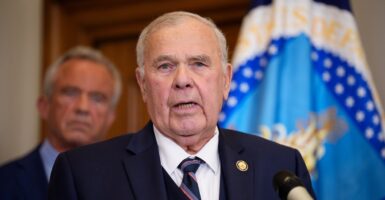 Rep. Jim Bairdspeaks at a podium in front of Robert F. Kennedy Jr.