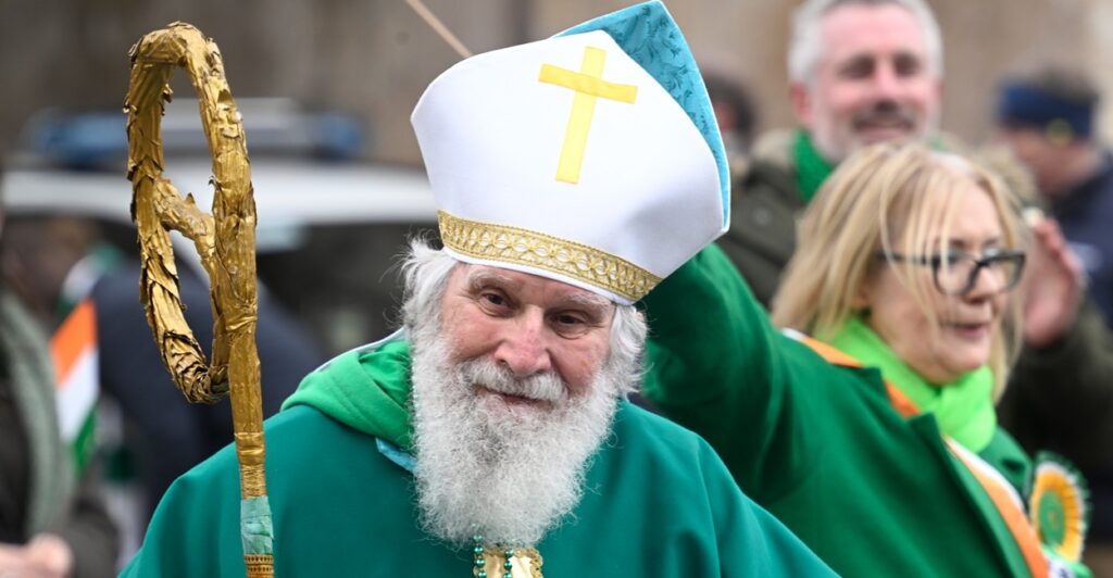 Man dressed as Saint Patrick outdoors.