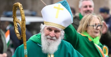 Man dressed as Saint Patrick outdoors.