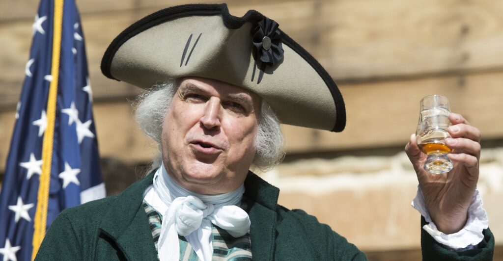 Geroge Washington reenactor holding up a glass.
