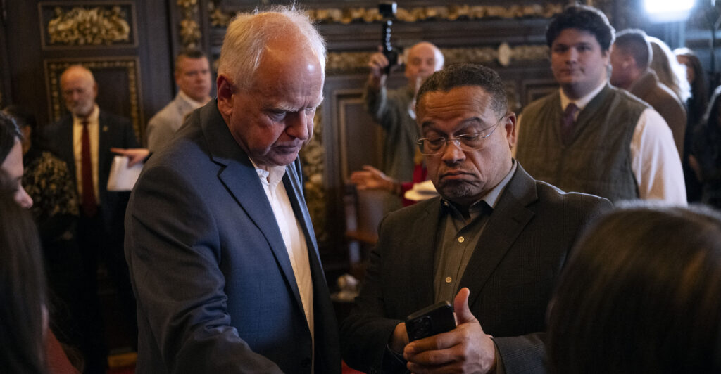 ST. PAUL, MINNESOTA - FEBRUARY 3: Minnesota Attorney General Keith Ellison (R) speaks with Minnesota Gov. Tim Walz (L) after a press conference about federal detention of children at the State Capitol building on February 3, 2026 in St. Paul, Minnesota. Trump administration officials intend to appeal a judges decision to release 5-year-old Liam Conejo Ramos who returned to Minnesota over the weekend after being held in a Texas immigration detention facility. (Photo by Stephen Maturen/Getty Images)