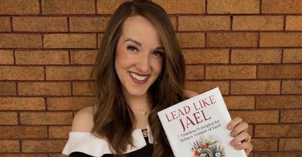 Author Emma Waters holding a copy of Lead Like Jael.