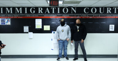 Masked federal agents stand in a hallway at the New York Federal Plaza Immigration Court inside the Jacob K. Javitz Federal Building in New York on March 5, 2026. US President Donald Trump has made deporting undocumented immigrants a key priority for his second term, after successfully campaigning against an alleged "invasion" by criminals. (Photo by CHARLY TRIBALLEAU / AFP via Getty Images)