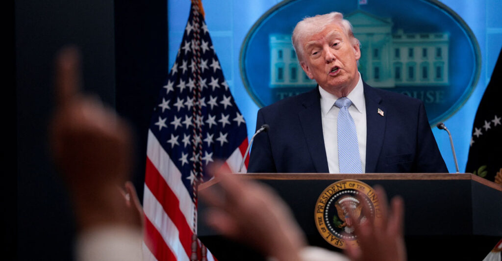 Donald Trump speaks to reporters from behind a podium in the White House briefing room.