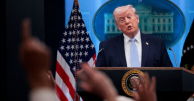 Donald Trump speaks to reporters from behind a podium in the White House briefing room.